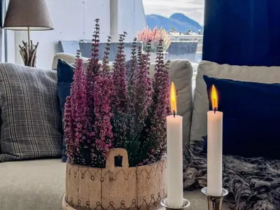 a vase filled with flowers on a couch with two candles at 4 star holiday home in HOVDEN in Hovden