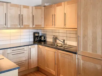 a kitchen with wooden cabinets and a sink at 4 star holiday home in HOVDEN in Hovden