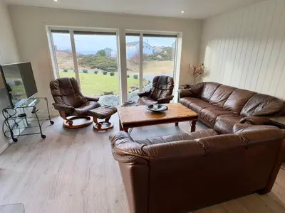 a living room with a leather couch and two chairs at 4 star holiday home in Tjeldstø in Tjeldstø