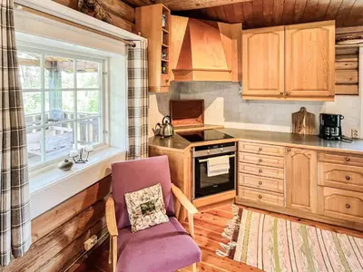 a kitchen with wooden cabinets and a chair and a window at 4 star holiday home in gol in Gol