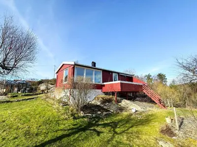 a red house sitting on top of a hill at 6 person holiday home in KLOKKARVIK in Klokkarvik