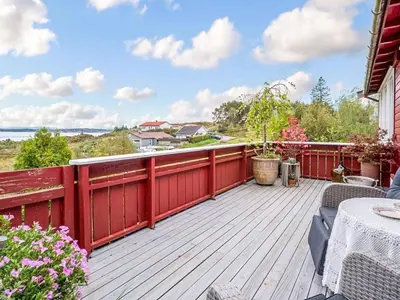 a wooden deck with a table and chairs on it at 6 person holiday home in KLOKKARVIK in Klokkarvik