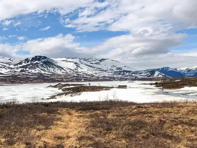 a snow covered mountain range with a house in the foreground at 4 star holiday home in Hemsedal in Hemsedal