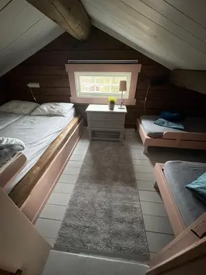 a attic bedroom with two beds and a window at Bjønnhiet in Trysil