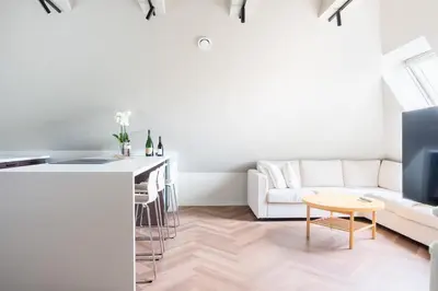 a white living room with a white couch and a table at Large apartment in historical street in Bergen