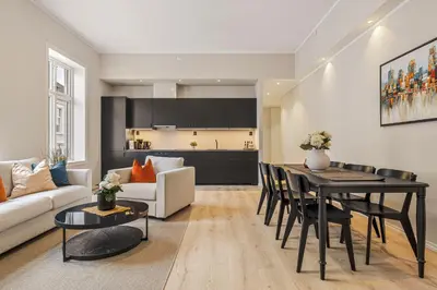 a living room with a table and a kitchen at Rosenberg Apartments in Bergen