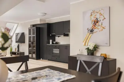 a kitchen and dining room with black cabinets at Rosenberg Apartments in Bergen