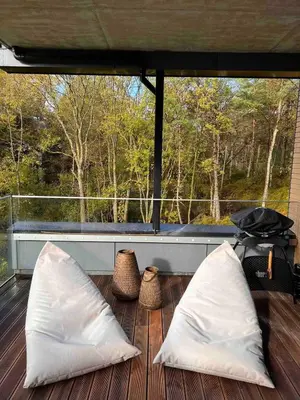 two white pillows on a deck with a view of trees at Luxury apartment with beautiful location in Florvåg