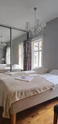 a bedroom with two beds and a large mirror at Øvregaten in Bergen