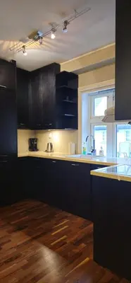 a kitchen with black cabinets and a wooden floor at Øvregaten in Bergen