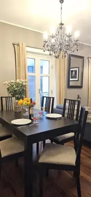 a black dining room table with chairs and a chandelier at Øvregaten in Bergen