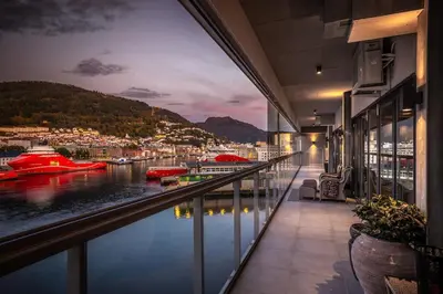 a balcony with a view of a river with boats at Exclusive Penthouse with Bryggen Views I MUST SEE in Bergen