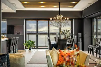 a dining room and living room with a table and chairs at Exclusive Penthouse with Bryggen Views I MUST SEE in Bergen
