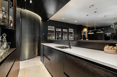 a kitchen with black walls and a white counter top at Exclusive Penthouse with Bryggen Views I MUST SEE in Bergen