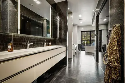 a bathroom with a sink and a large mirror at Exclusive Penthouse with Bryggen Views I MUST SEE in Bergen