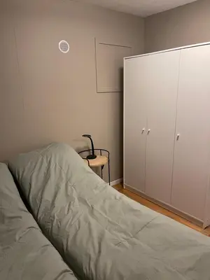 a bedroom with a bed and a white cabinet at Sjøutsikt in Bergen