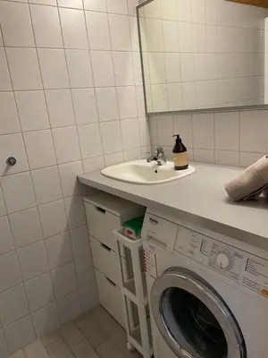 a bathroom with a washing machine and a sink at Sjøutsikt in Bergen