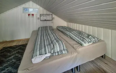a bed in a room with a roof at Lovely Home In Mosterhamn With Sauna in Mosterhamn