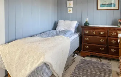 a bedroom with a bed and a wooden dresser at Amazing Home In Averøy With Wifi in Averoy