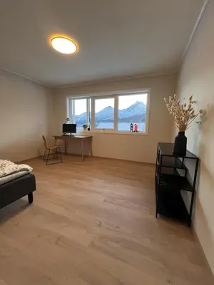 an empty living room with a desk and a window at Mountain View apartment in Isfjorden