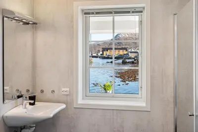 a bathroom with a sink and a window at Komfortable Ferieleiligheter med Sjøutsikt in Stadlandet