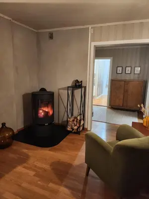 a living room with a fireplace and a couch at Idyllic Snekkerstuvarpet with its own pier in Lillehammer