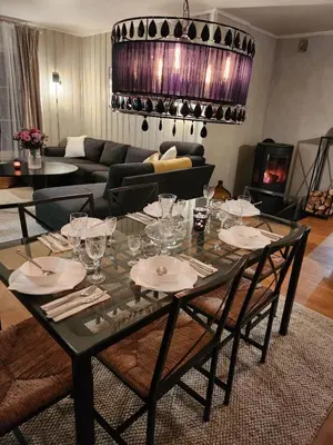 a dining room with a table with glasses on it at Idyllic Snekkerstuvarpet with its own pier in Lillehammer