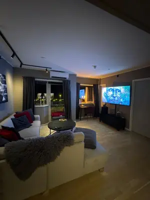 a living room with a couch and a flat screen tv at 3-room downtown apartment in Trondheim