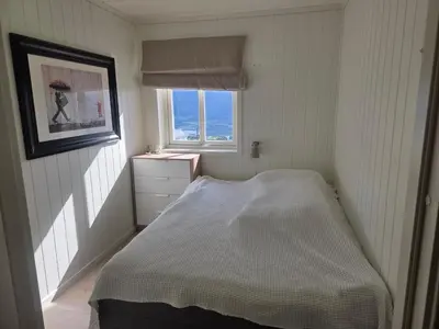 a small bedroom with a bed and a window at Apartment Tråstølen ski in ski out in Vossevangen