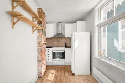 a white refrigerator in a kitchen with a window at Bergen Gem Straight Out of History - Built in 1750 in Bergen