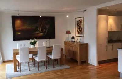 a dining room with a table and white chairs at Nice appartment in Bergens best location in Bergen