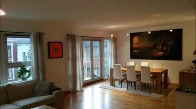 a living room with a dining room table and chairs at Nice appartment in Bergens best location in Bergen