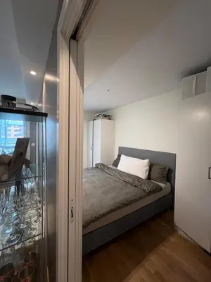 a bedroom with a bed and a glass door at Centrally located apartment in Bergen