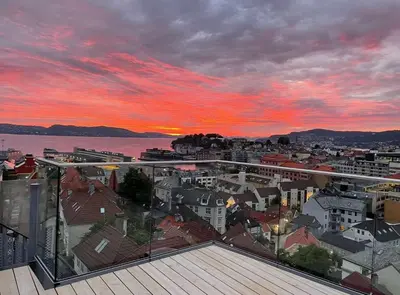 a view of a city at sunset from a building at DINBNB Apartments l Luxury Penthouse l Roof Terrace l Central Bergen in Bergen