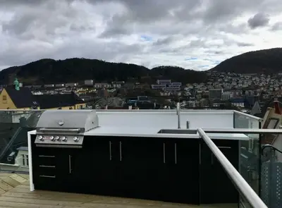 a kitchen with a stove and a view of a city at DINBNB Apartments l Luxury Penthouse l Roof Terrace l Central Bergen in Bergen
