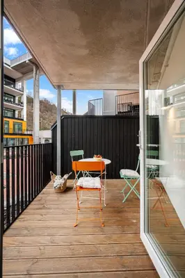 a room with a table and chairs on a balcony at Helt ny leilighet Ytre Sandviken in Bergen