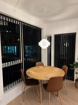a dining room with a table and chairs and large windows at Helt ny leilighet Ytre Sandviken in Bergen