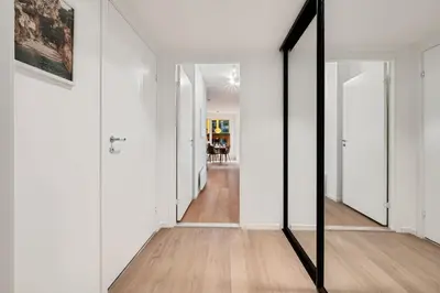 a mirror in a hallway with white walls and wooden floors at Helt ny leilighet Ytre Sandviken in Bergen