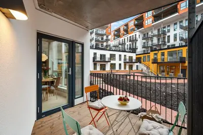 a balcony with a table and chairs and a view of a city at Helt NY leilighet, Ytre Sandviken i Bergen in Bergen