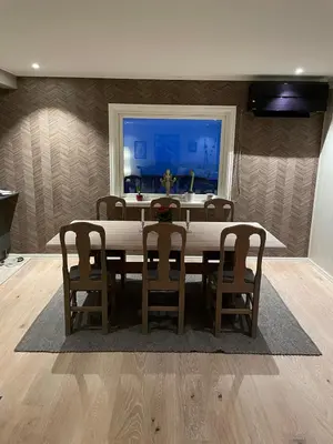 a dining room with a table and chairs and a window at Lars sitt hus in Lillehammer