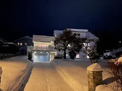 a house is covered in snow at night at Lars sitt hus in Lillehammer