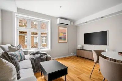 a living room with a couch and a tv at Bergen Beds - Modern, Cozy & Perfect Location in Bergen