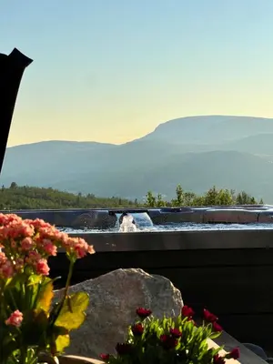 a hot tub with a view of the mountains at The Heritage Lodge - Geilo in Geilo
