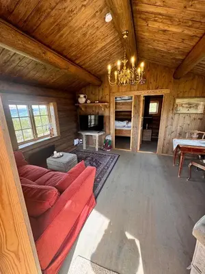 a living room with a red couch and a table at The Heritage Lodge - Geilo in Geilo