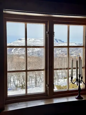 a window with a view of snow covered mountains at The Heritage Lodge - Geilo in Geilo