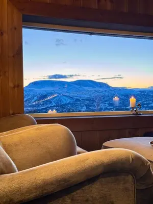 a room with chairs and a large window with a view at The Heritage Lodge - Geilo in Geilo