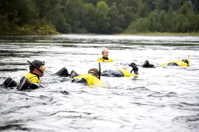 a group of people in the water in a river at Mo Laksegard in Sand