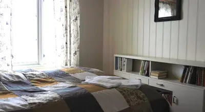 a bedroom with a bed with a window and a shelf at Jordbærstova Feriehus in Valldal