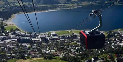 a gondola flying over a village in front of a lake at Large single-family home - Central in Voss in Vossevangen