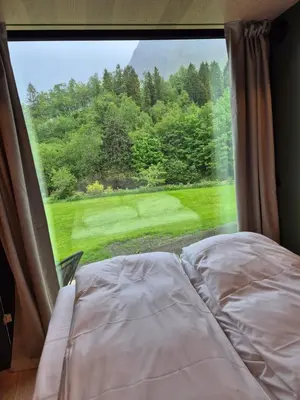 a bed in a room with a large window at Hytte Grøtdalstind, Rekkedal Gjestegard - Sæbø in Sæbø